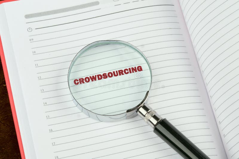 Una lupa resalta la palabra crowdsourcing (colaboración colectiva) en una página de cuadernos alineados que enfatiza el concepto en un contexto de estudio o investigación sobre las contribuciones.