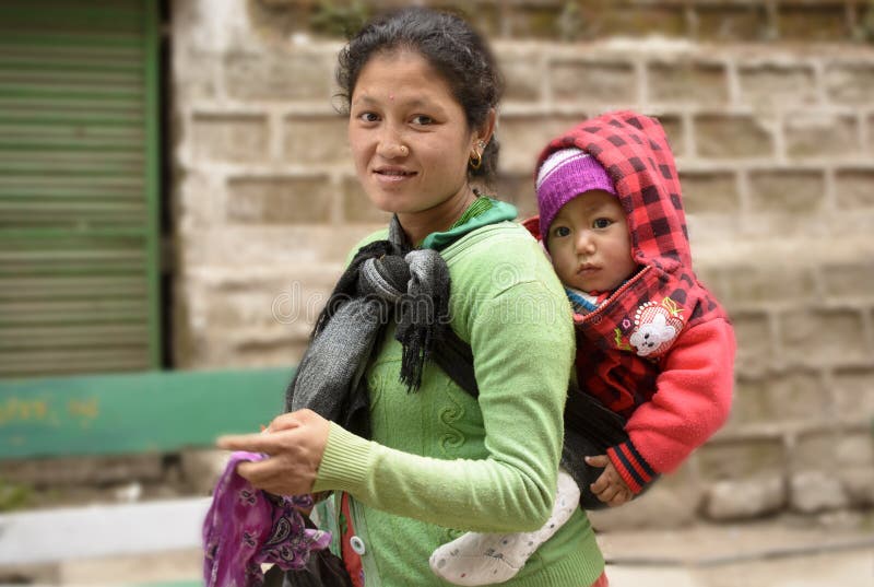 Una madre que lleva a su poco niño en ella de nuevo a trabajo imagen de archivo libre de regalías Una madre que lleva a su poco niño en ella de nuevo a trabajo imagen de archivo libre de regalías