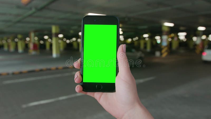 Una mano che tiene un telefono con uno schermo verde