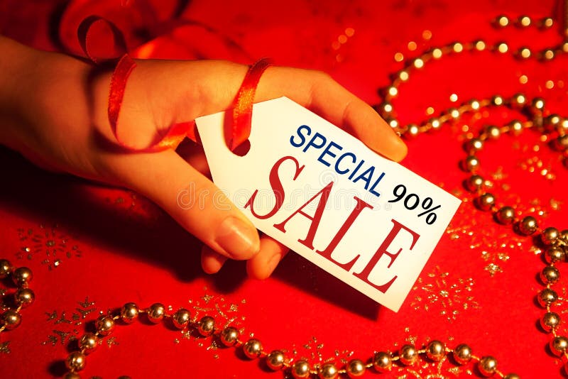 A woman`s hand holds a label with the text a special sale, with a 90 percent discount for shop windows, shopping malls and advertising backgrounds, during the Christmas and New Year holidays. A woman`s hand holds a label with the text a special sale, with a 90 percent discount for shop windows, shopping malls and advertising backgrounds, during the Christmas and New Year holidays.