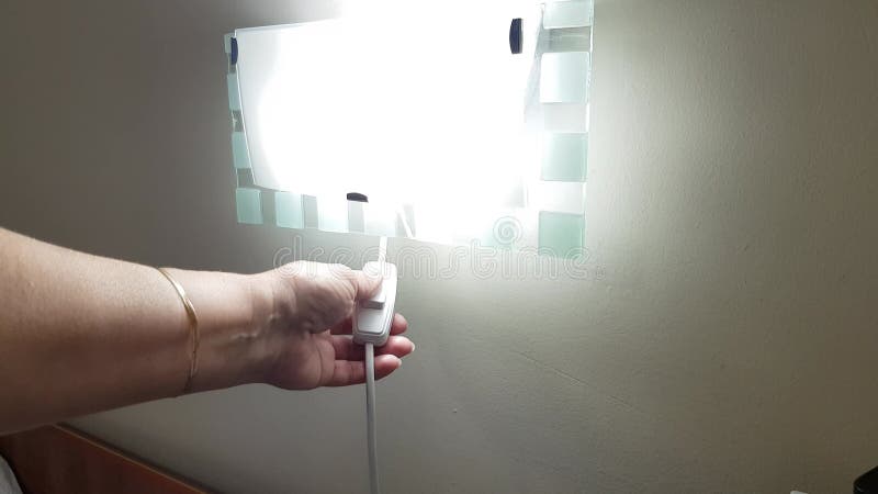 Una mano di donna accende una lampada notturna appesa al muro video 4k