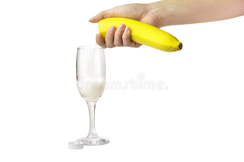 Una mano femenina vierte el jugo fresco del plátano derecho de la fruta en un vidrio alto, como de un paquete de jugo imágenes de archivo libres de regalías Una mano femenina vierte el jugo fresco del plátano derecho de la fruta en un vidrio alto, como de un paquete de jugo imágenes de archivo libres de regalías