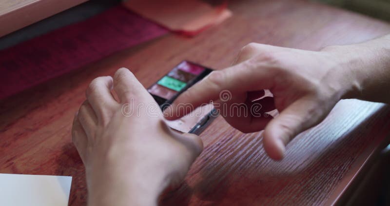 Una mano masculina aplica corrector en la palma en un camerino metrajes