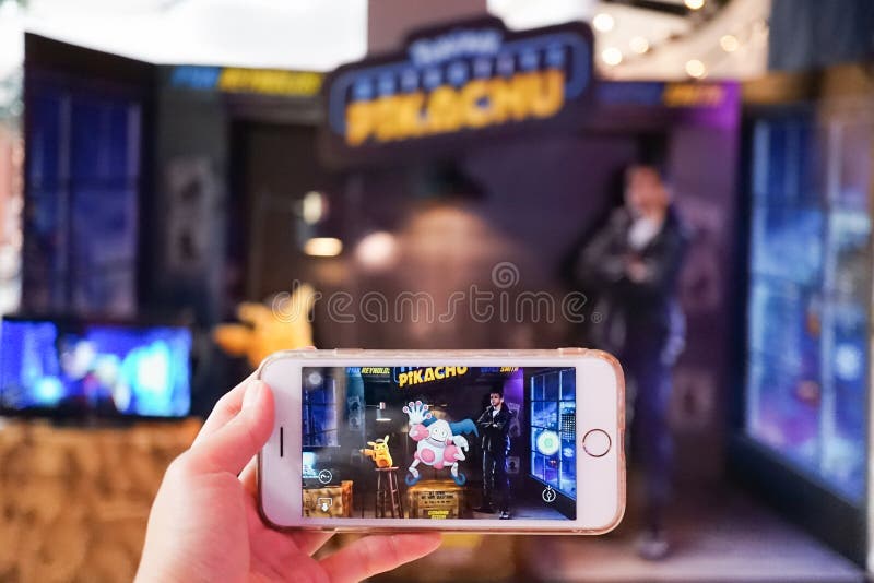 Una mano que sostiene el teléfono elegante que juega Pokemon va modo de AR con el foco en Sr. mime foto de archivo libre de regalías Una mano que sostiene el teléfono elegante que juega Pokemon va modo de AR con el foco en Sr. mime foto de archivo libre de regalías
