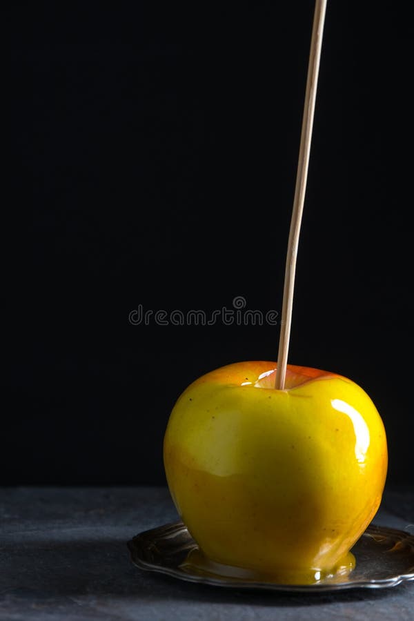 Una manzana de caramelo en una pequeña placa de lata imagen de archivo libre de regalías Una manzana de caramelo en una pequeña placa de lata imagen de archivo libre de regalías