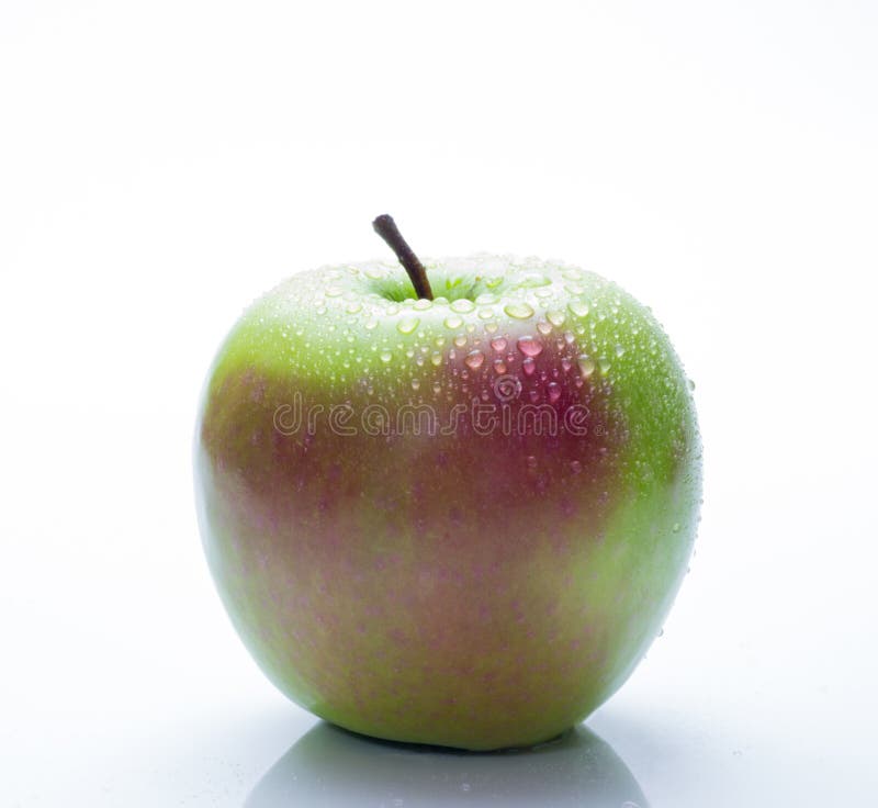 Una manzana roja y verde con descensos del agua aislada en un fondo blanco imagenes de archivo Una manzana roja y verde con descensos del agua aislada en un fondo blanco imagenes de archivo