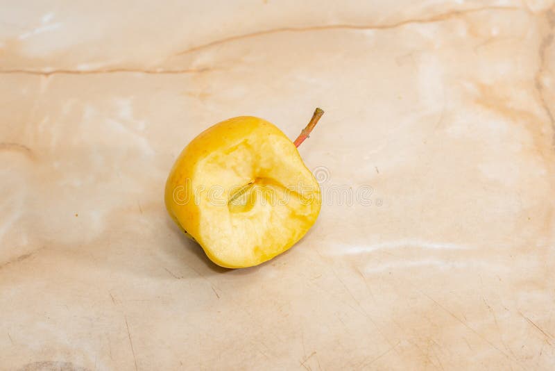 Una mela morsa gialla giace in cucina su un tavolo beige fotografia stock libera da diritti Una mela morsa gialla giace in cucina su un tavolo beige fotografia stock libera da diritti