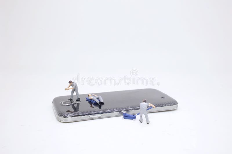 una mini gente que repara el teléfono elegante agrietado imagen de archivo una mini gente que repara el teléfono elegante agrietado imagen de archivo