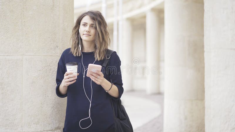 Una muchacha blanca morena está escuchando la música al aire libre fotografía de archivo libre de regalías Una muchacha blanca morena está escuchando la música al aire libre fotografía de archivo libre de regalías