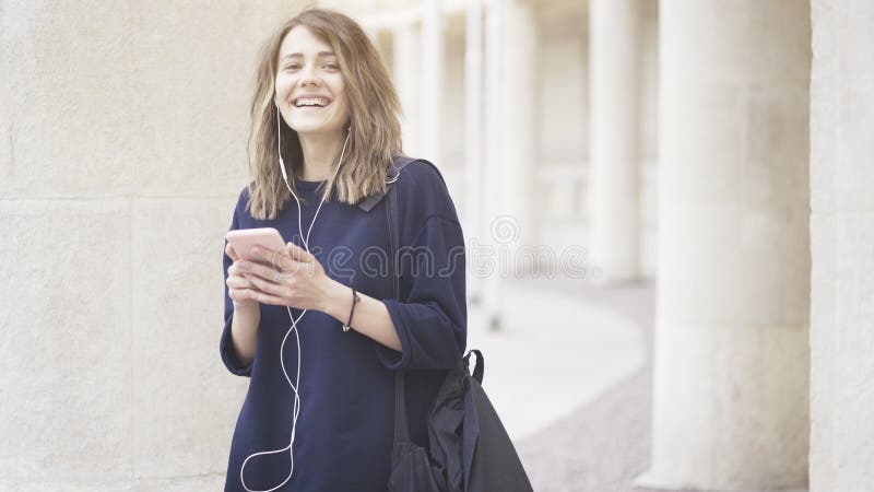 Una muchacha blanca morena feliz de risa está escuchando la música al aire libre fotografía de archivo Una muchacha blanca morena feliz de risa está escuchando la música al aire libre fotografía de archivo