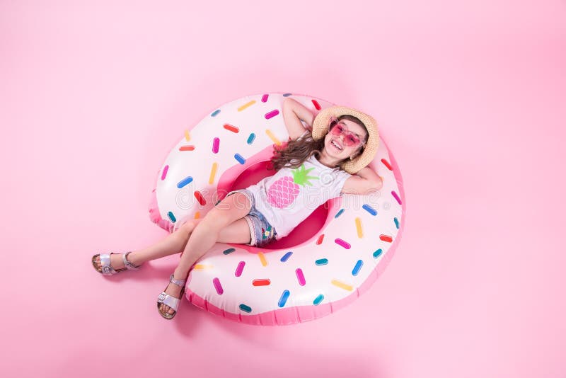 Una muchacha del peque?o ni?o que miente en un c?rculo inflable del bu?uelo Fondo rosado Visi?n superior Concepto del verano fotografía de archivo libre de regalías Una muchacha del peque?o ni?o que miente en un c?rculo inflable del bu?uelo Fondo rosado Visi?n superior Concepto del verano fotografía de archivo libre de regalías