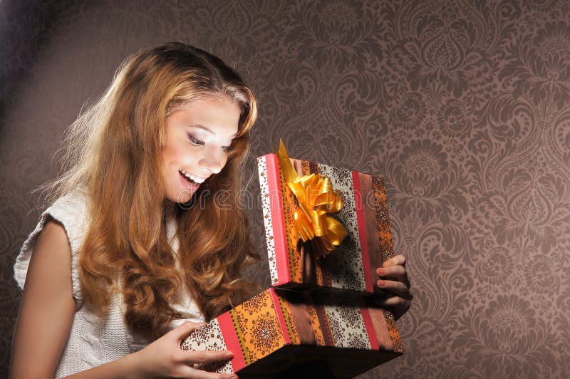 Una muchacha feliz del teenge que abre un regalo de Navidad fotos de archivo libres de regalías Una muchacha feliz del teenge que abre un regalo de Navidad fotos de archivo libres de regalías