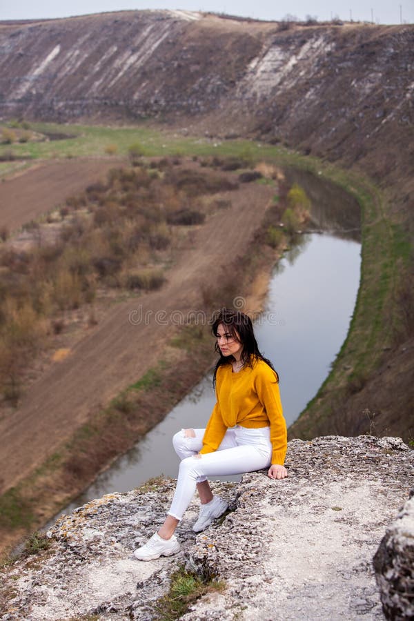 Una muchacha joven del viajero se sienta en el top del valle Vida salvaje del amor de la chica joven, viaje, libertad fotografía de archivo Una muchacha joven del viajero se sienta en el top del valle Vida salvaje del amor de la chica joven, viaje, libertad fotografía de archivo