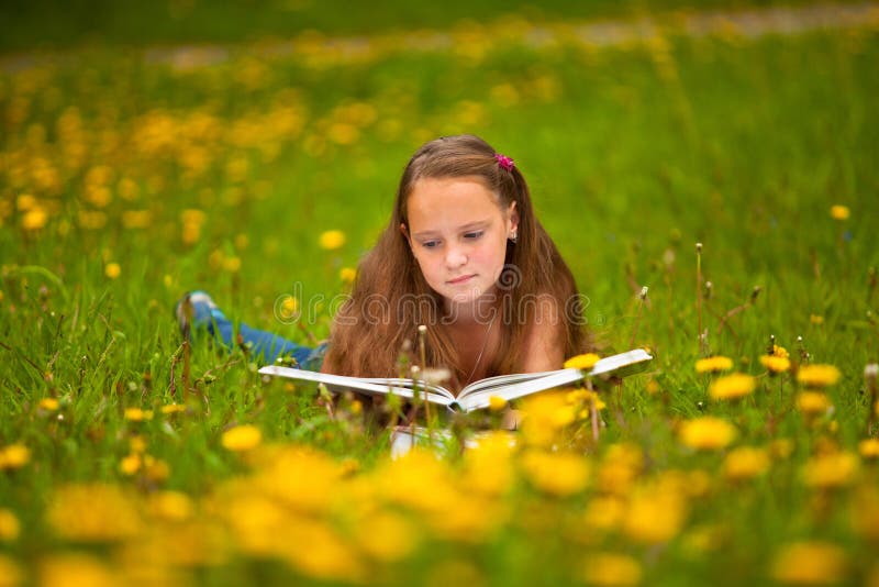 A girl (11 years old) reads a book in the meadow. A girl (11 years old) reads a book in the meadow.