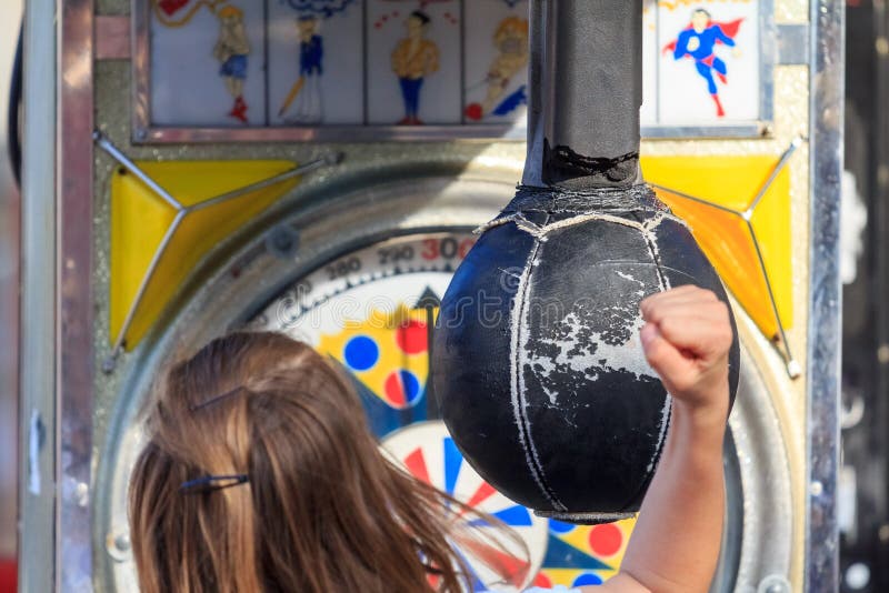 Una muchacha que golpea un bolso de sacador del parque de atracciones fotografía de archivo Una muchacha que golpea un bolso de sacador del parque de atracciones fotografía de archivo