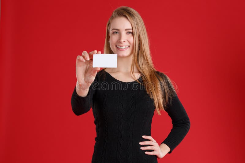 Una muchacha, sosteniendo una tarjeta de visita y un tablero blanco con los papeles, y una sonrisa linda fotografía de archivo Una muchacha, sosteniendo una tarjeta de visita y un tablero blanco con los papeles, y una sonrisa linda fotografía de archivo