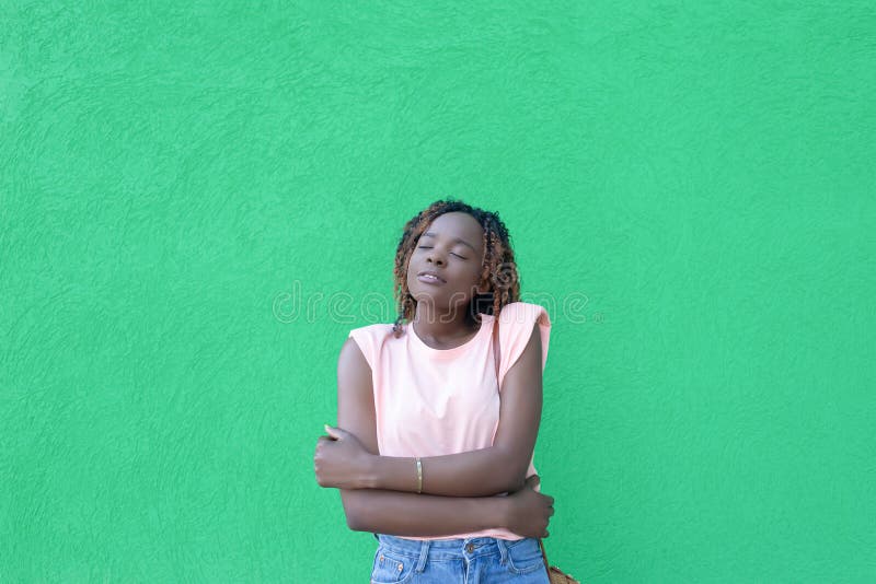 Una mujer afroamericana sonriente y feliz con un fondo verde. emociones positivas. romance fotografía de archivo