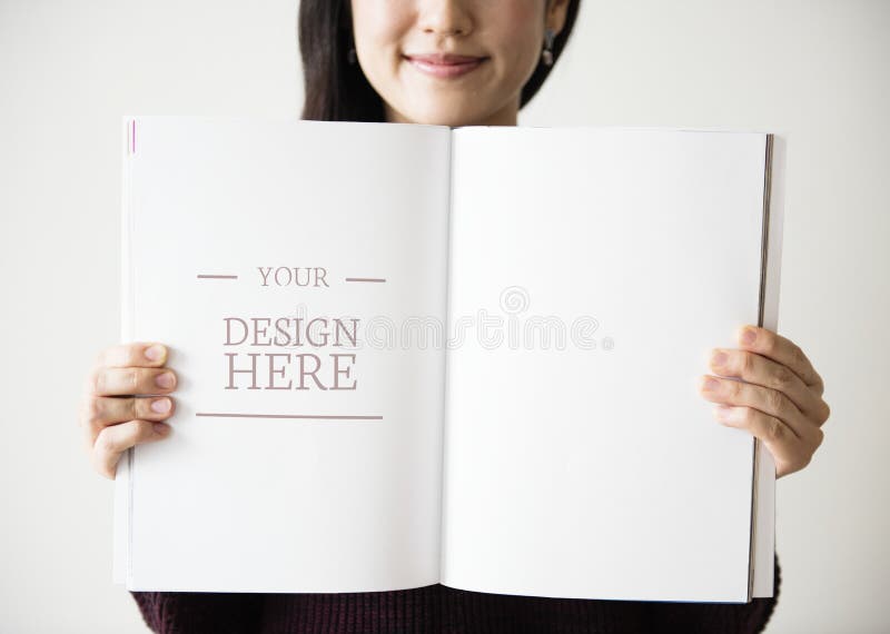 Una mujer asiática está sosteniendo una revista en blanco imagenes de archivo Una mujer asiática está sosteniendo una revista en blanco imagenes de archivo