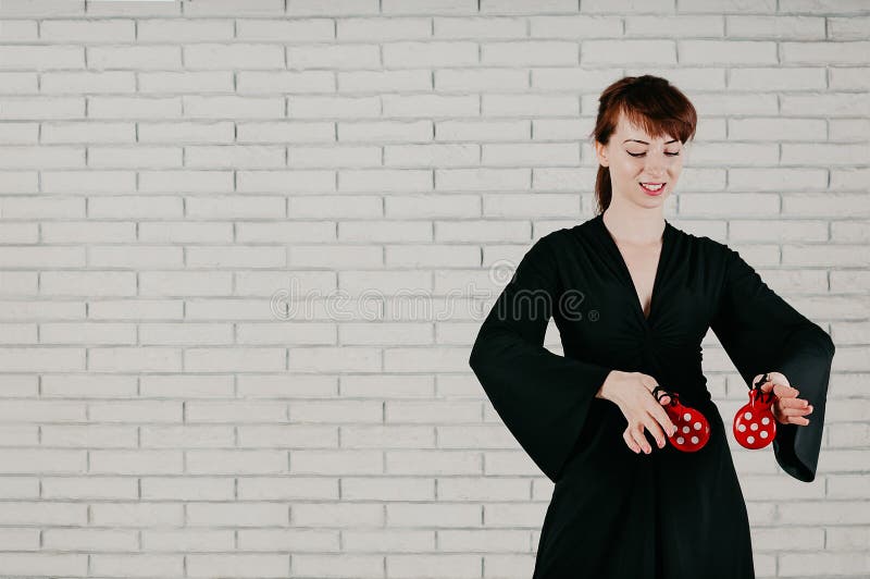 Una mujer atractiva joven en el vestido negro, bailando con castan rojo imagen de archivo libre de regalías Una mujer atractiva joven en el vestido negro, bailando con castan rojo imagen de archivo libre de regalías
