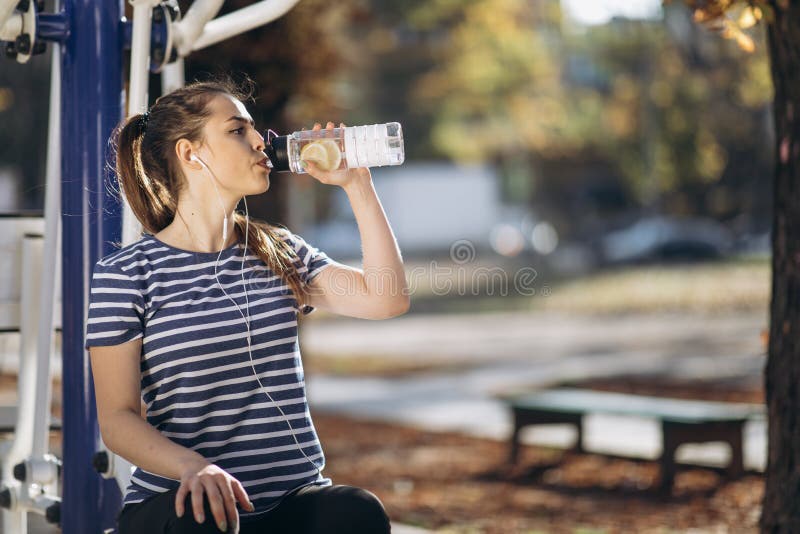 Una Mujer Bebe Agua De Un Agitador Después Del Entrenamiento Mujer  Deportiva Bebe De Un Gimnasio En El Fondo De Los árboles Depor Imagen de  archivo - Imagen de bebida, ocasional: 163882527