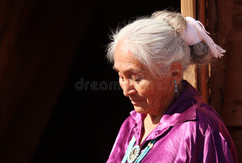 Una mujer de Navajo que mira abajo al aire libre en Sun brillante