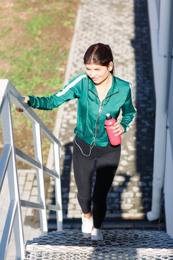 Una mujer deportiva joven con el cuerpo perfecto que hace ejercicios en las escaleras al aire libre imágenes de archivo libres de regalías Una mujer deportiva joven con el cuerpo perfecto que hace ejercicios en las escaleras al aire libre imágenes de archivo libres de regalías