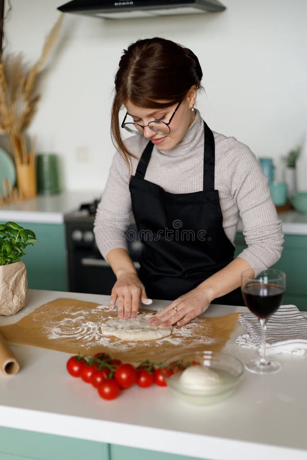 Una Mujer En Un Delantal Cocina Pizza De Margarita En La Cocina