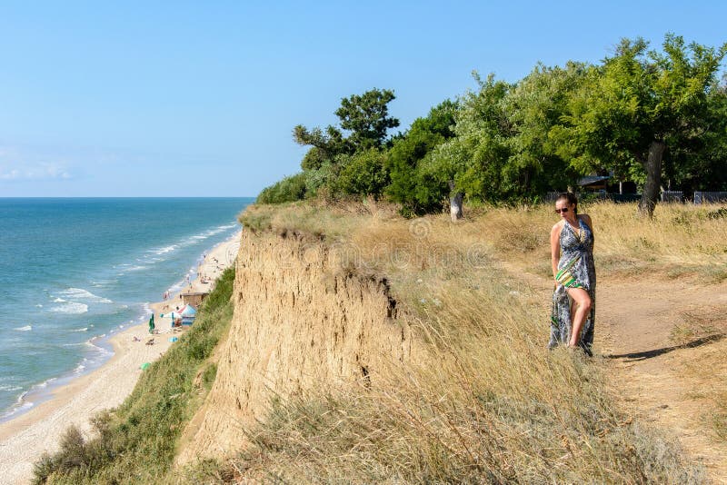 Una mujer hermosa en un vestido verde está sobre la alta playa imagenes de archivo Una mujer hermosa en un vestido verde está sobre la alta playa imagenes de archivo