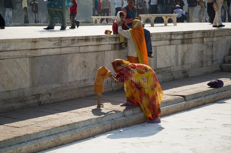Una mujer india viste a su pequeño niño cerca del templo Familia india La India, Agra 31 de enero de 2009 foto de archivo libre de regalías Una mujer india viste a su pequeño niño cerca del templo Familia india La India, Agra 31 de enero de 2009 foto de archivo libre de regalías