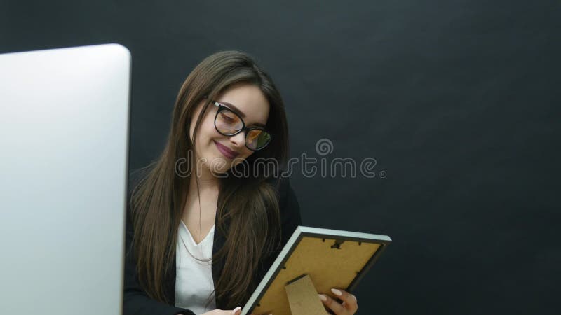 Una mujer joven en la oficina mira la foto