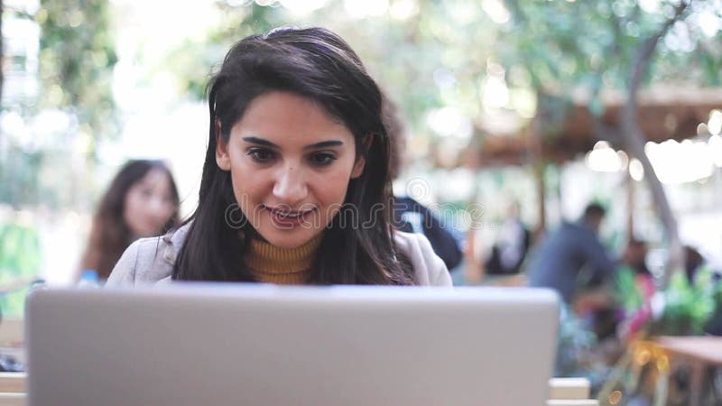 Una mujer muy joven usa un ordenador en el jardín