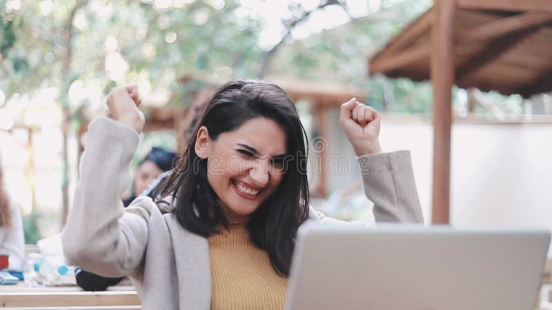Una mujer muy joven usa un ordenador en el jardín metrajes
