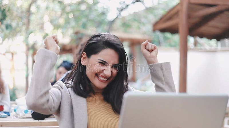 Una mujer muy joven usa un ordenador en el jardín