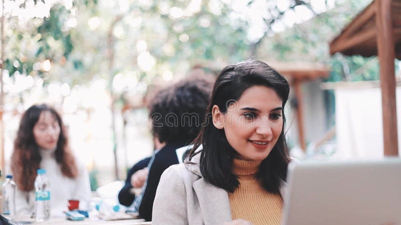 Una mujer muy joven usa un ordenador en el jardín metrajes