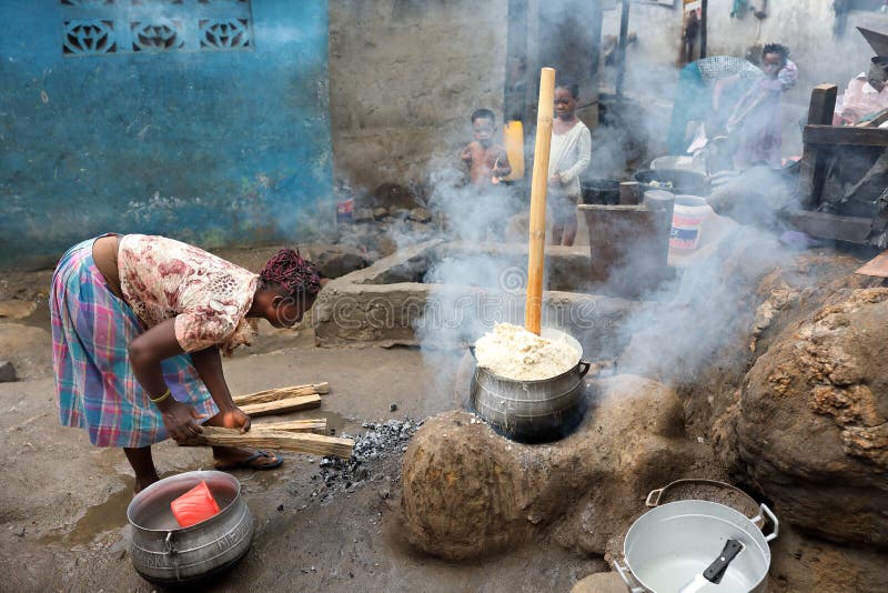 A woman prepares traditional corn porridge on open fire in Winneba, Ghana. A woman prepares traditional corn porridge on open fire in Winneba, Ghana