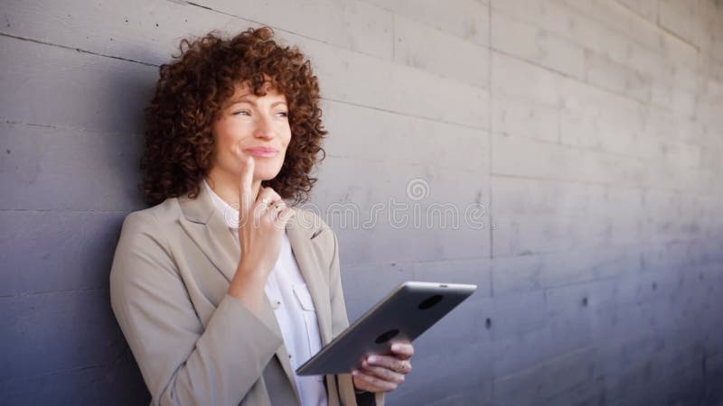 Una mujer profesional comprometida activamente con su tablet en un espacio de oficinas moderno y elegante metrajes