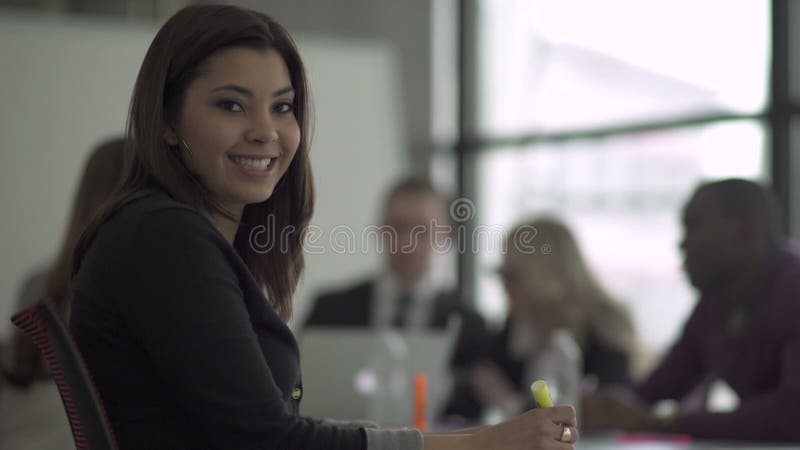 Una mujer profesional de la raza mixta mira la cámara (2 de 2) metrajes