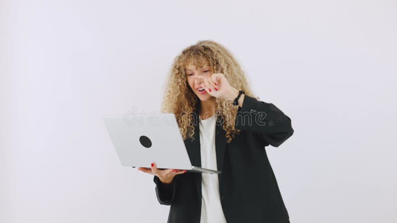 Una mujer profesional enfocada en su laptop mientras participaba activamente en un espacio de trabajo moderno mostrando su dedicac almacen de metraje de vídeo