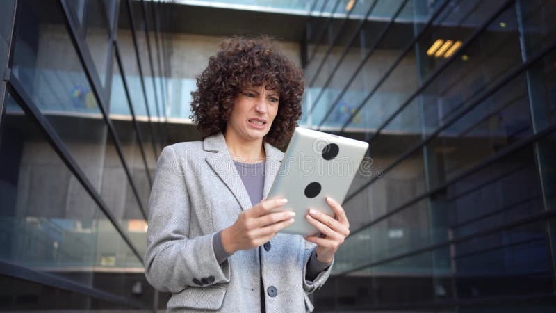 Una mujer profesional que usa hábilmente una tableta en un entorno urbano de vanguardia hoy almacen de metraje de vídeo