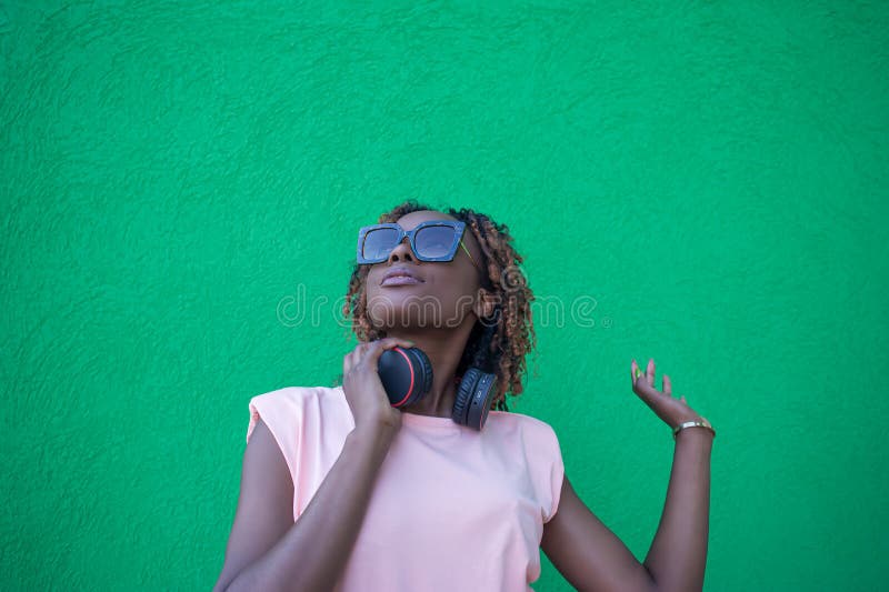 Una mujer sonriente y feliz escucha música con auriculares. tecnologías inalámbricas foto de archivo