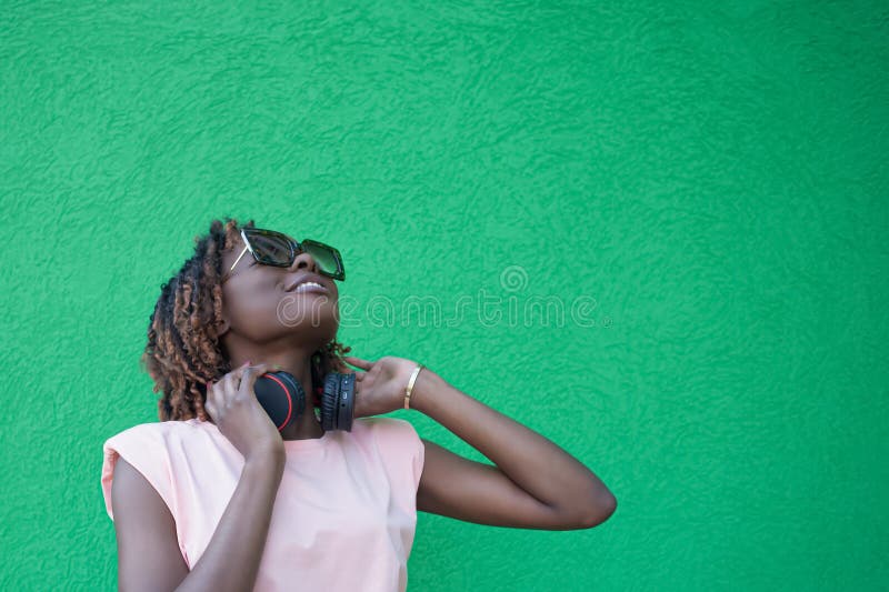 Una mujer sonriente y feliz escucha música con auriculares. tecnologías inalámbricas. espacio de copia foto de archivo libre de regalías