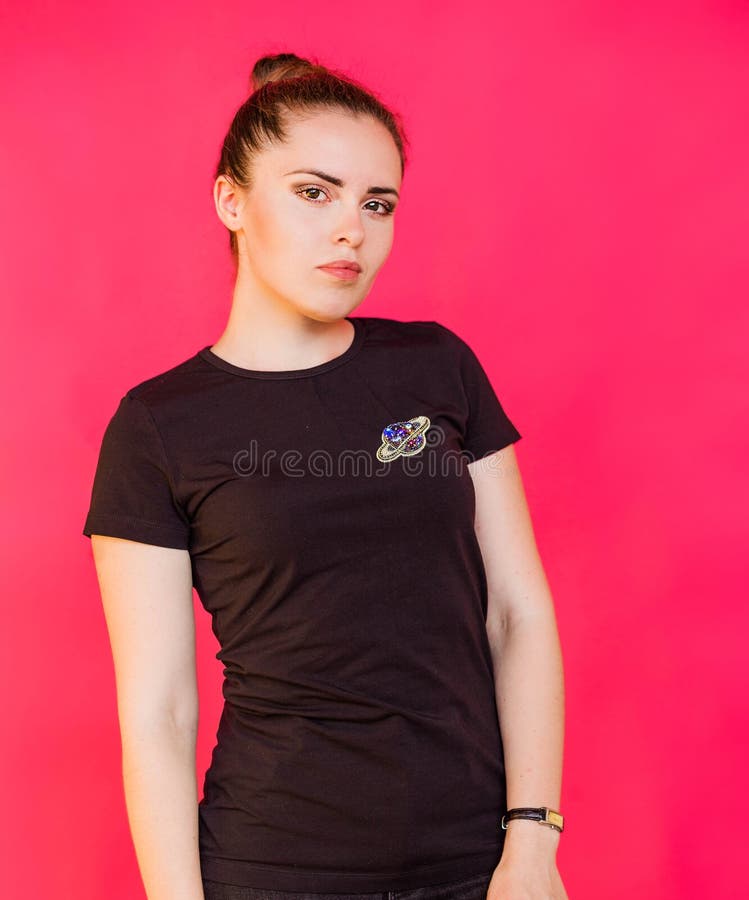 Una Niña Con Una Camiseta Negra Con Un Broche En Forma De Planeta Con  Anillos Posa Contra Un Fondo De Fucsia Imagen de archivo - Imagen de  elegante, belleza: 267925189