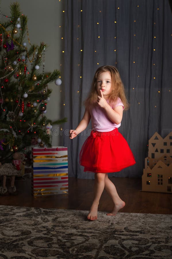 Una Niña De Falda Roja Está Bailando Para El Año Nuevo. La Chica Del árbol  De Navidad Se Está Divirtiendo En Casa Imagen de archivo - Imagen de  persona, muchacha: 193153261
