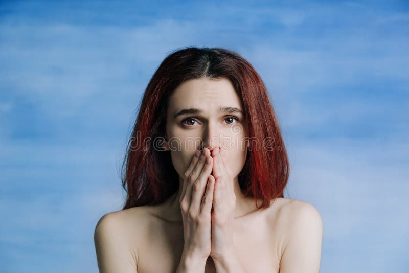 Una niña, con los hombros desnudos, se cubrió la boca con gestos silenciosos en las manos fotos de archivo Una niña, con los hombros desnudos, se cubrió la boca con gestos silenciosos en las manos fotos de archivo