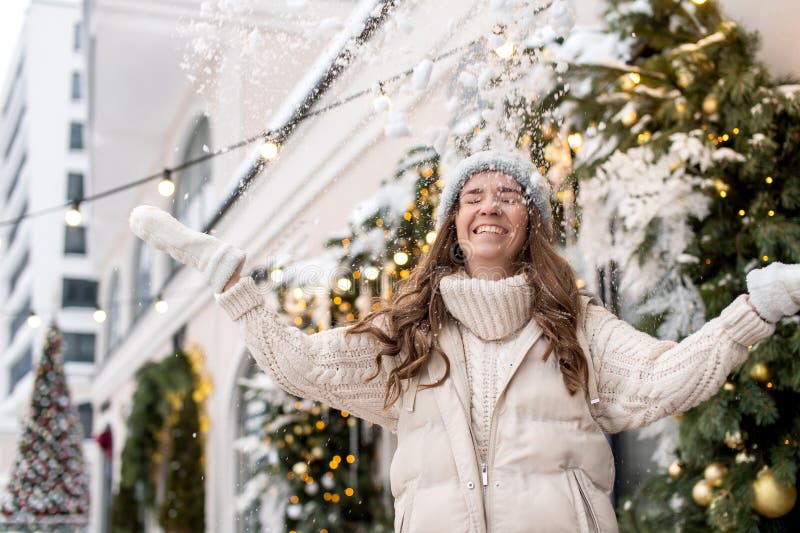 Una niña feliz camina por la ciudad y arroja nieve foto de archivo