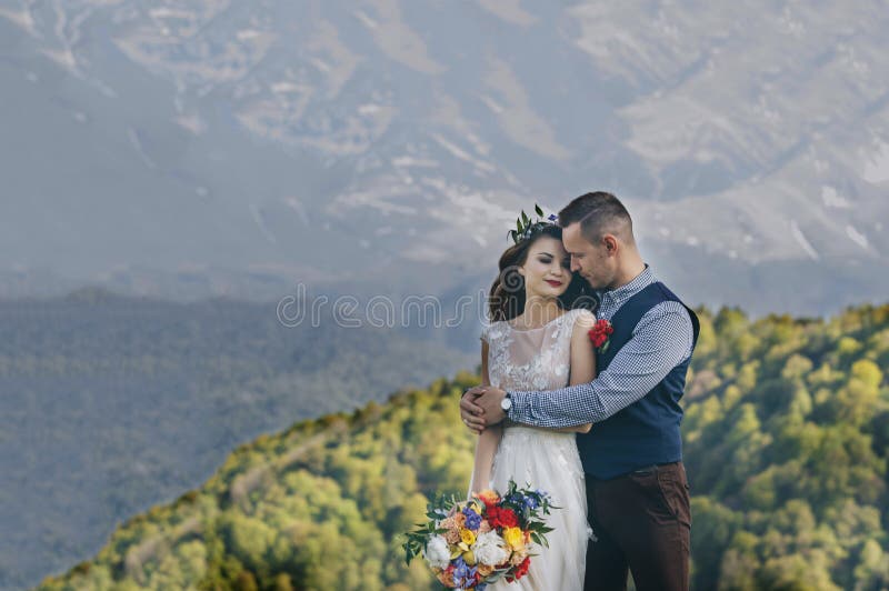 Una novia y un novio disfrutan de una vista de la capilla del soporte en el fondo de este alto viñedo del lagar de la elevación fotos de archivo