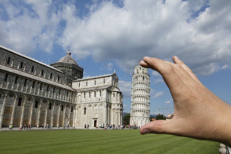 Una opinión de perspectiva falsa de la diversión tonta de la mano de los photographer’s que lleva a cabo el belltower medieval de la catedral de Pisa, sabe comúnmente como la torre inclinada de Pisa Pisa, Toscana, Italia - 20 de mayo de 2016
