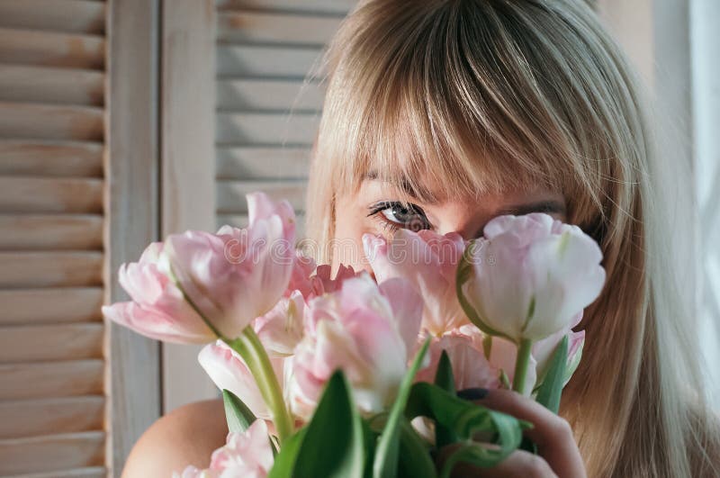 Una opinión del primer una mujer rubia con las flores rosadas fotografía de archivo Una opinión del primer una mujer rubia con las flores rosadas fotografía de archivo