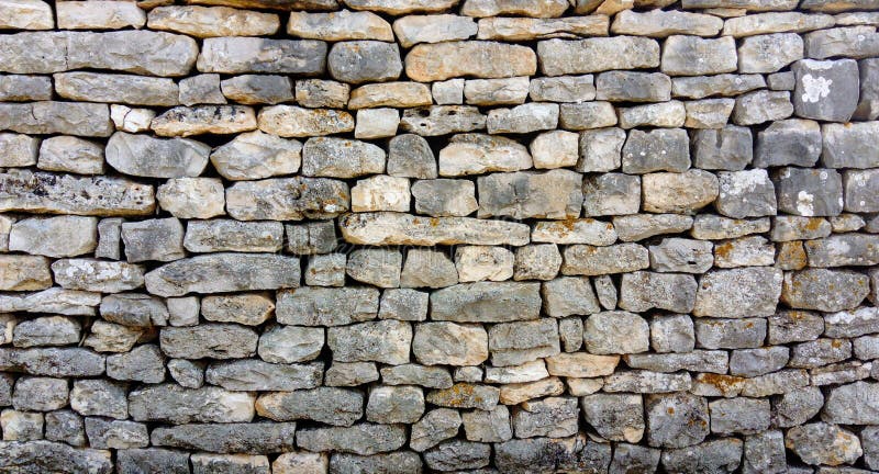Una pared de piedra de diversas formas sin el cemento imagen de archivo libre de regalías Una pared de piedra de diversas formas sin el cemento imagen de archivo libre de regalías