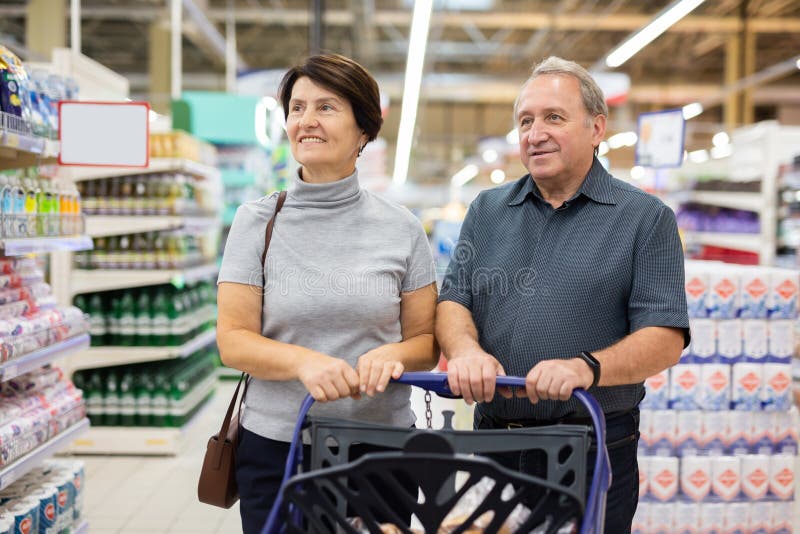 Una pareja casada elige comestibles juntos en un supermercado foto de archivo